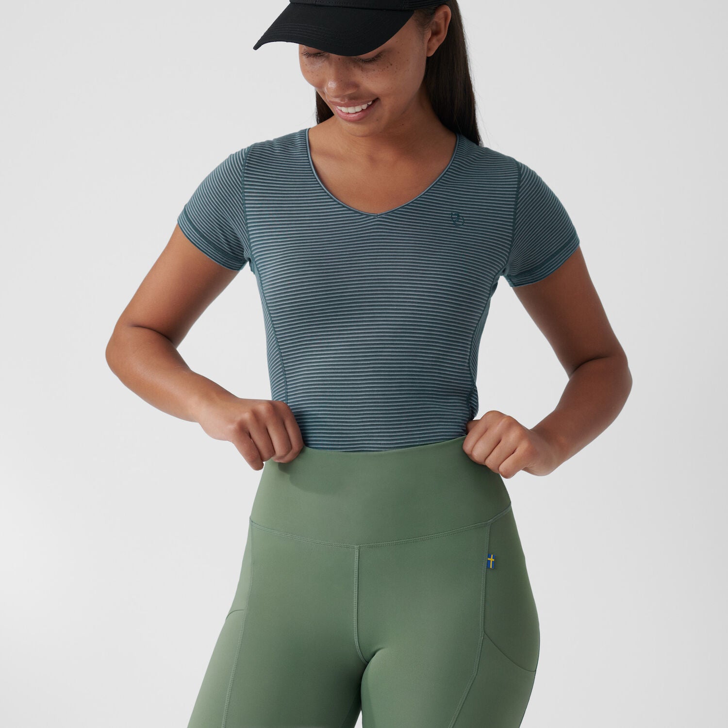 a girl is standing wearing branded & durable green slim fit women trousers.
