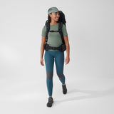 a girl is walking wearing branded & durable blue slim fit women trousers and fjallraven 1960 logo hat and a hooodie with backpack on her back.