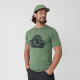 A man is wearing  branded green wool winter men t-shirt with printing a fox logo and Fjällräven original written around it. 