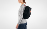 a girl wearing classic kanken backpack coving with kanken rain cover