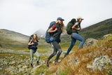 three girls are trekking wearing branded & durable black slim fit women trousers and fjallraven 1960 logo hat and a hooodie with backpack on her back.