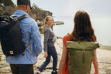two women and one man wearing fjallraven product like shirts, t-shirts, trousers, kanken, totepack, ulvo rolltop and hip pack are roming at the bank of a lake