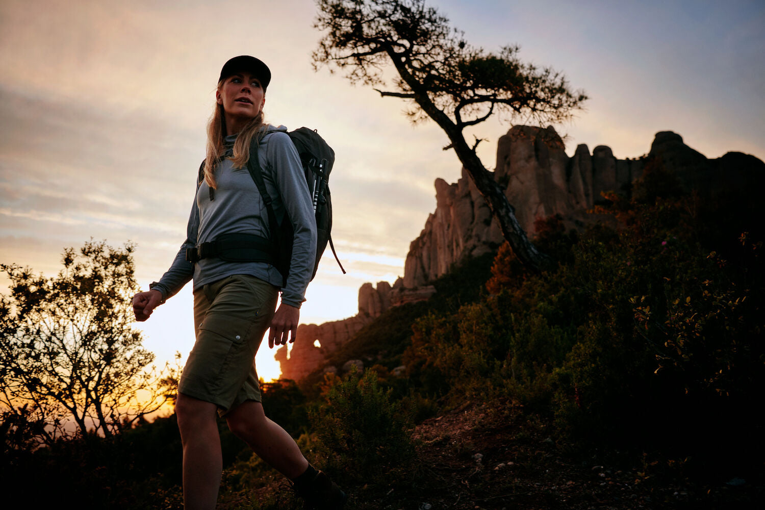 one women is trekking at the time of sun set with wearing fjallraven products