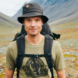 A man is wearing premium branded fjallraven t-shirt and branded fox hat. 